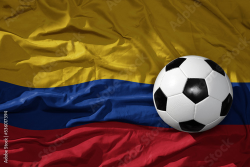 vintage football ball on the waveing national flag of colombia background. 3D illustration