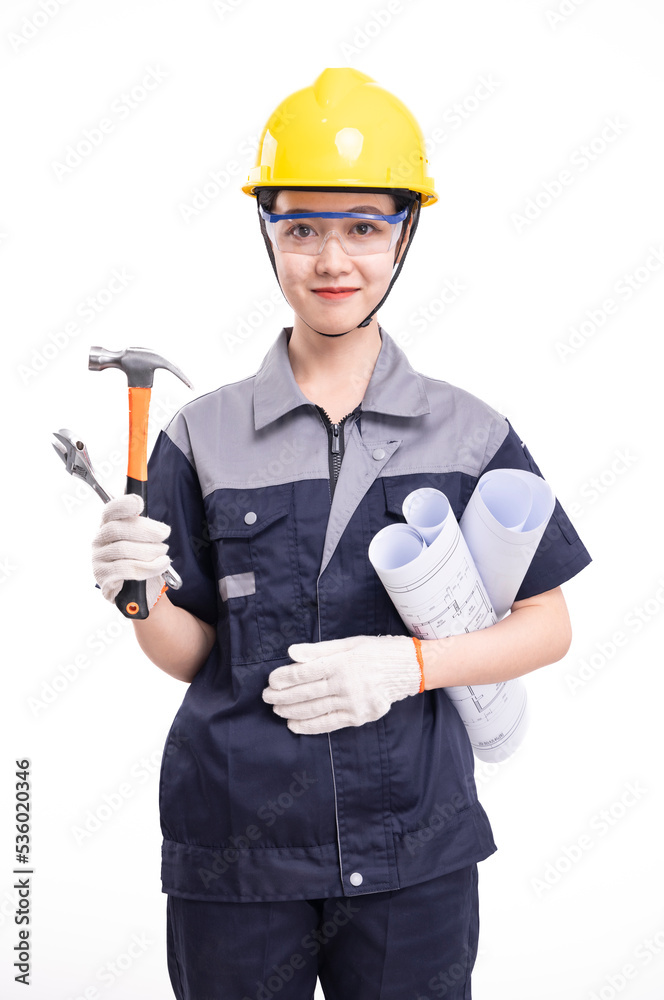 A female worker in a hard hat and uniform carrying tools A female worker in a hard hat and uniform carrying tools