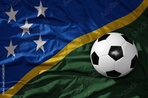 vintage football ball on the waveing national flag of Solomon Islands background. 3D illustration
