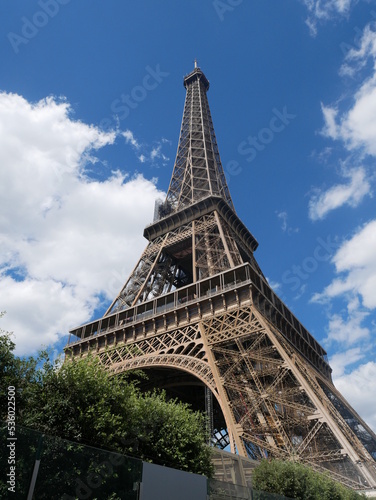 Paris, France: low angle view of the Eiffel Tower in Paris, against cloudy blue sky 
