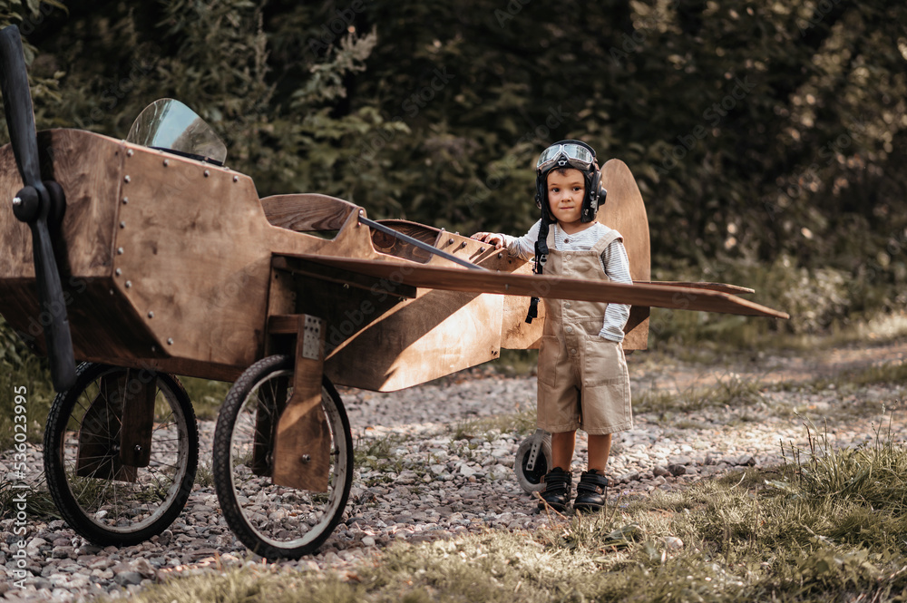 A young boy aviator on a homemade airplane in a natural landscape Authentic mood of the picture. Vintage.