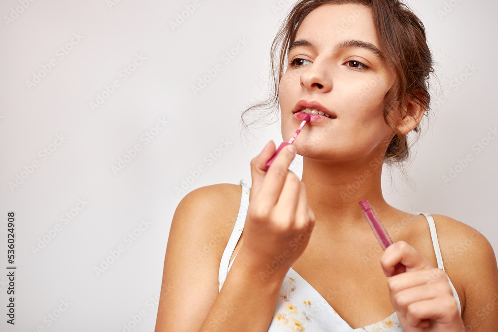 Beautiful girl uses red lipstick. Selection and use of cosmetics. Beautiful girl uses red lipstick. Selection and use of cosmetics.
