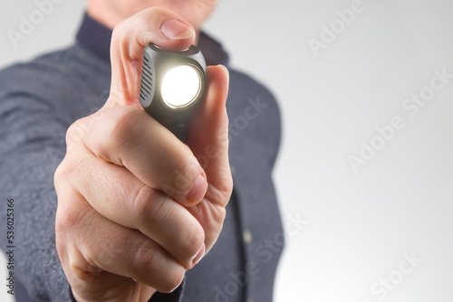 man holds a flashlight in his hand. item for camping and household life
