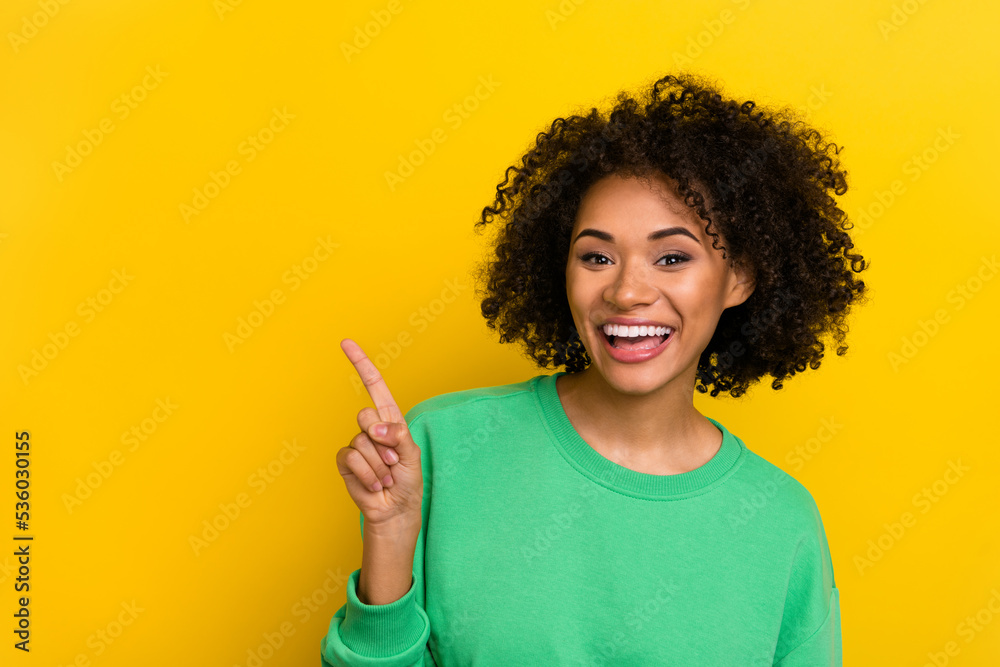 Photo of funny positive lady indicate finger empty space promo isolated on yellow color background Photo of funny positive lady indicate finger empty space promo isolated on yellow color background