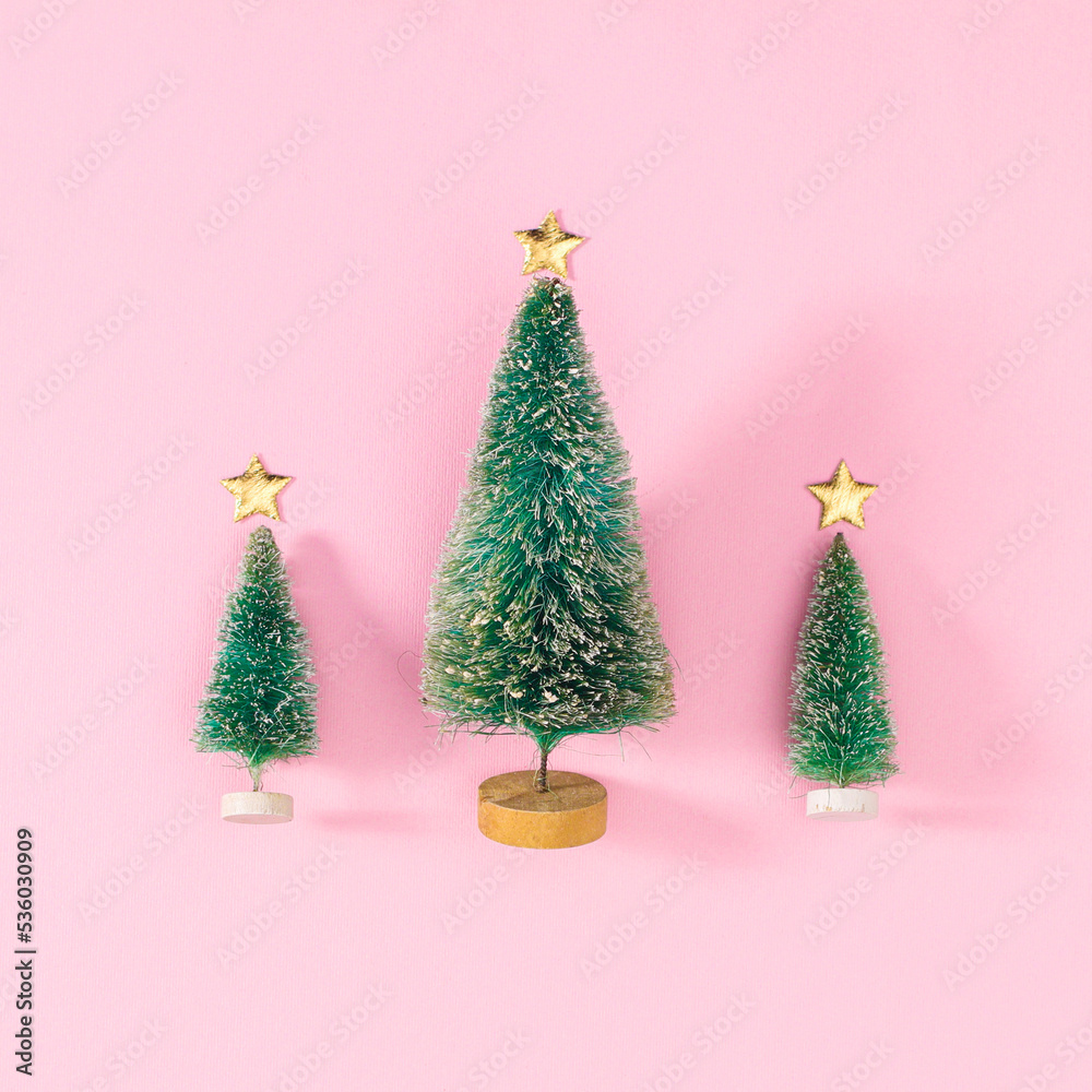 Three Christmas trees on pastel pink background. Flat lay Three Christmas trees on pastel pink background. Flat lay