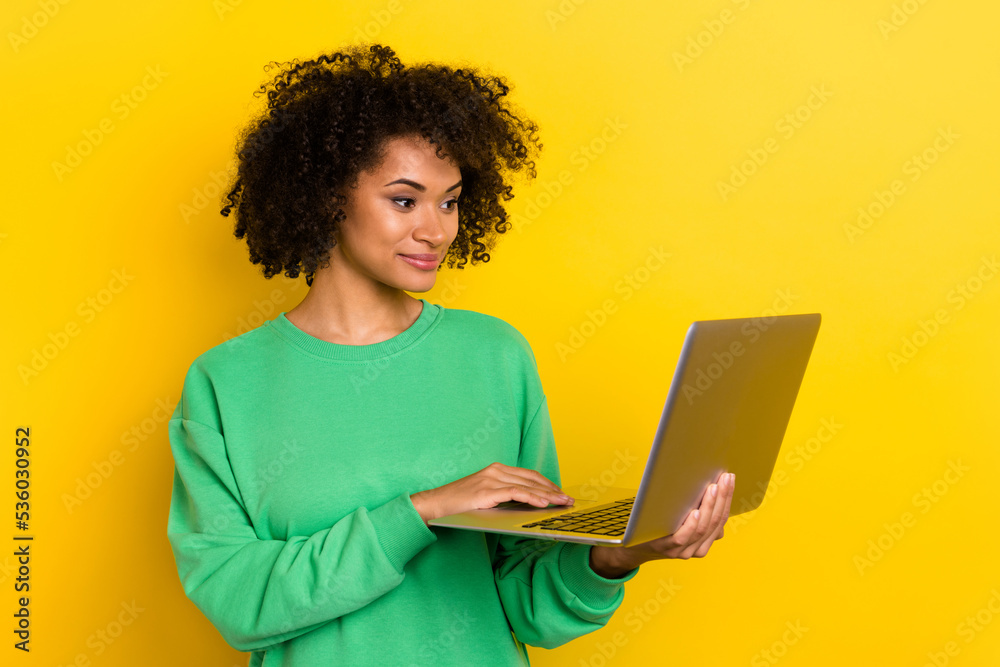 Photo of smart intelligent curly lady use wireless netbook write email isolated on yellow color background Photo of smart intelligent curly lady use wireless netbook write email isolated on yellow color background