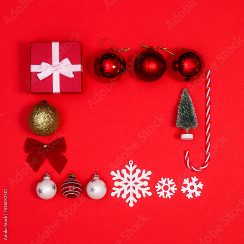 Creative Christmas layout with ornaments frame on red background. FLat lay copy space