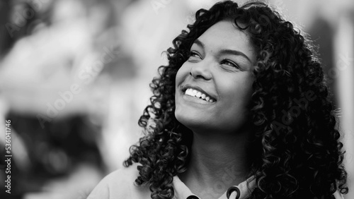 One young black woman closeup face looking at sky. Monochromatic and artistic