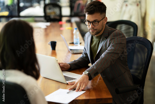 Businessman gives businesswoman dismissal contract to sign.