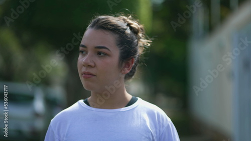 One contemplative hispanic girl walking forward in city street. Casual young latin woman in 20s in contemplation going for a walk 2 © Marco