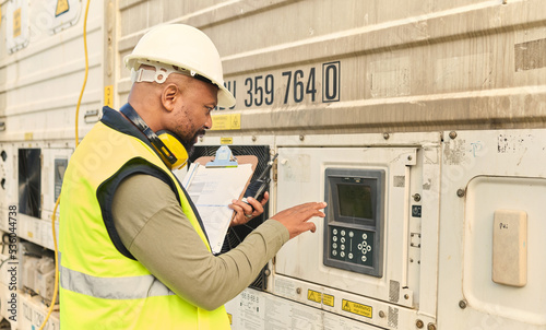 Logistics, supply chain and security with a man shipping professional using a keypad password on on a commercial container dock. Documents, delivery and storage with a male courier at work with stock