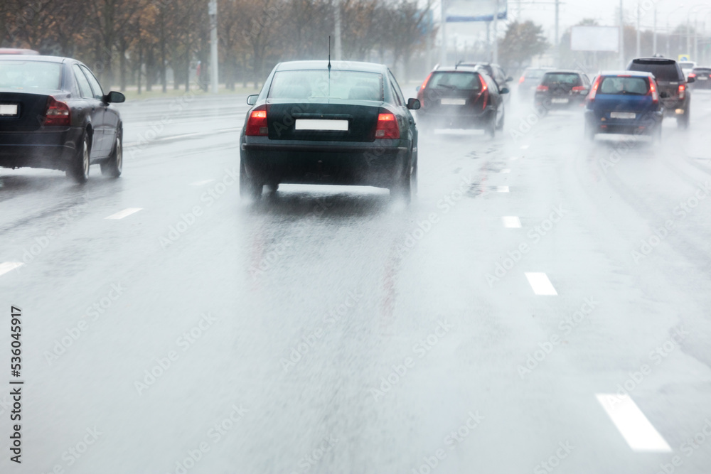 car in motion spraying water puddles from the wheels during rainy weather car in motion spraying water puddles from the wheels during rainy weather