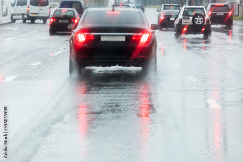 rainy road. driving cars on a wet street with splashing water in motion blur.