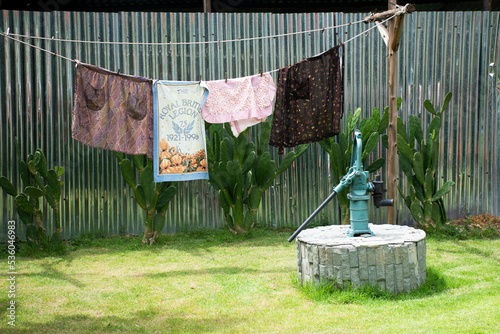 Classic vintage retro antique manual pump water ground of artesian water well and drying clothes for thai people use at outdoor garden park at rural countryside in Nonthaburi, Thailand photo