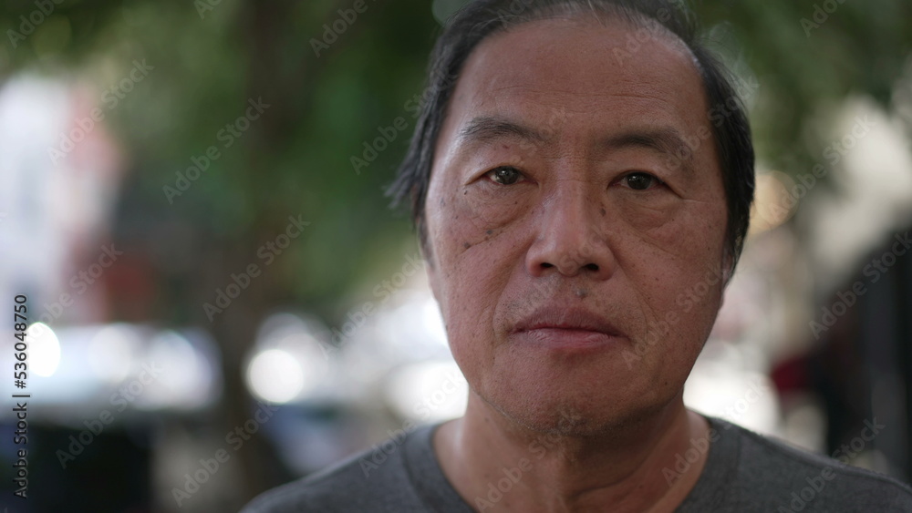 Portrait of an Asian American older man looking at camera. Closeup face of a middle aged Japanese male person Portrait of an Asian American older man looking at camera. Closeup face of a middle aged Japanese male person