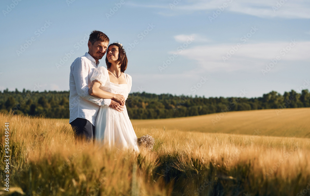 Couple just married. Together on the majestic agricultural field at sunny day Couple just married. Together on the majestic agricultural field at sunny day