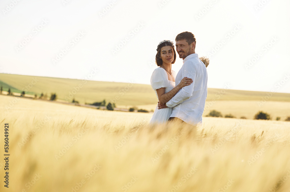 Standing and enjoying the nature. Couple just married. Together on the majestic agricultural field at sunny day Standing and enjoying the nature. Couple just married. Together on the majestic agricultural field at sunny day
