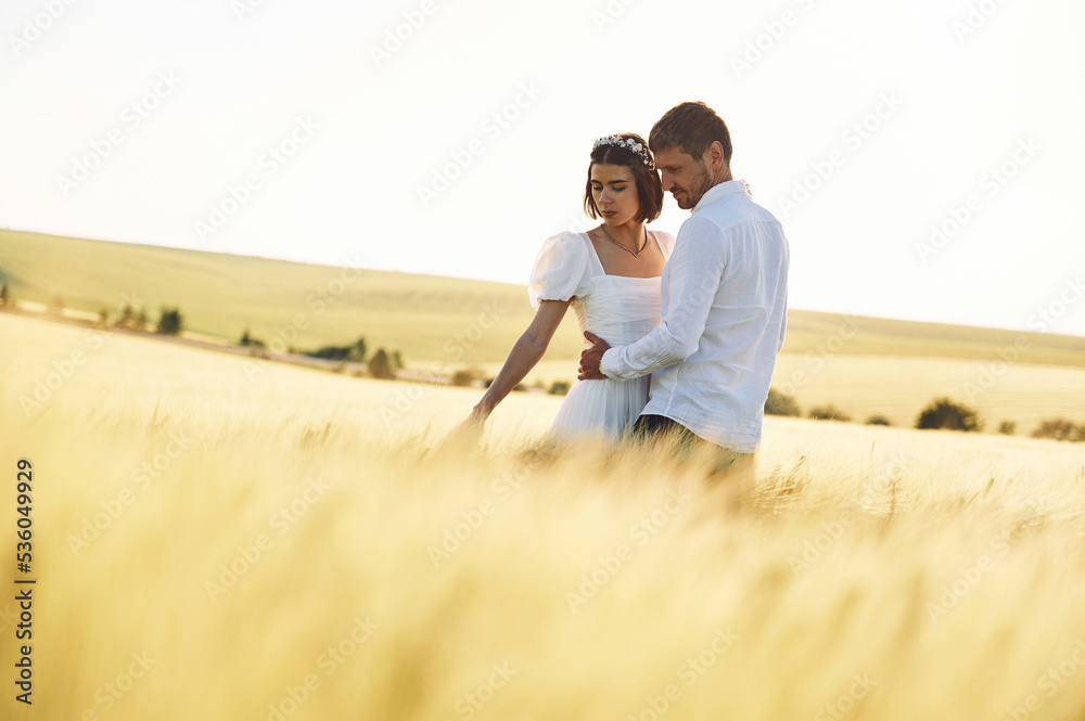 Standing and enjoying the nature. Couple just married. Together on the majestic agricultural field at sunny day Standing and enjoying the nature. Couple just married. Together on the majestic agricultural field at sunny day