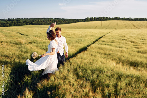 In dress and formal clothes. Couple just married. Together on the majestic agricultural field at sunny day
