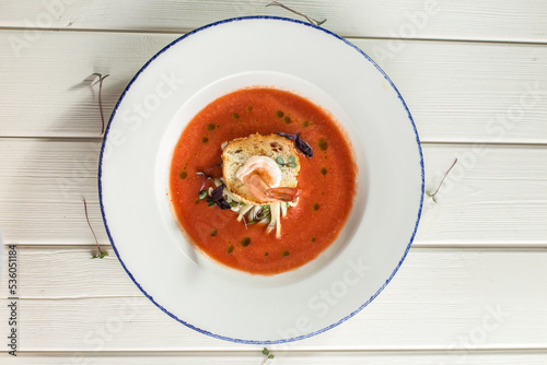 Shrimps with parsley, bread and red sauce on a plate on the table