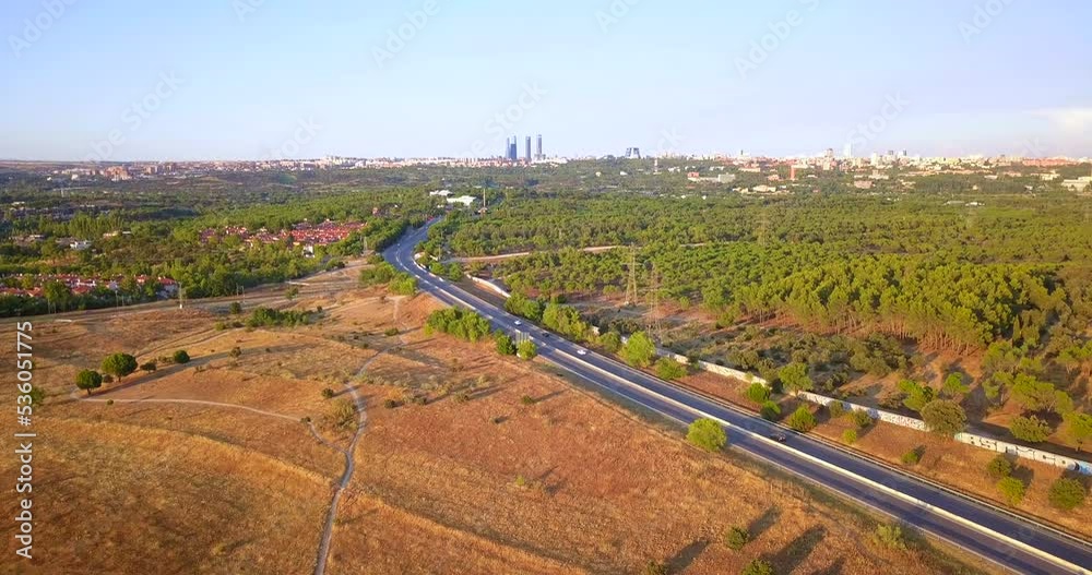 Cinematic aerial view of freeway towards Madrid city center at sunset. Vehicles traveling to Madrid Cinematic aerial view of freeway towards Madrid city center at sunset. Vehicles traveling to Madrid