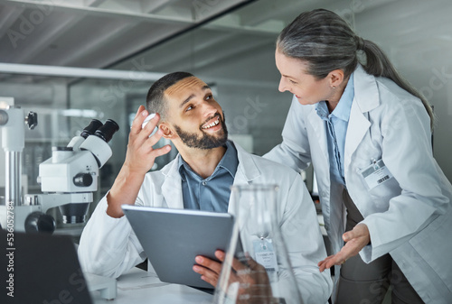 Science, man and woman consulting in laboratory doing research in hospital. Technology, medical innovation and communication, university lab worker and scientist or mentor checking information online