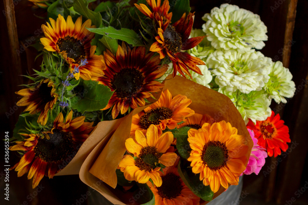 Φωτογραφία bouquets of yellow and white flowers and sunflowers in paper brown wrapper