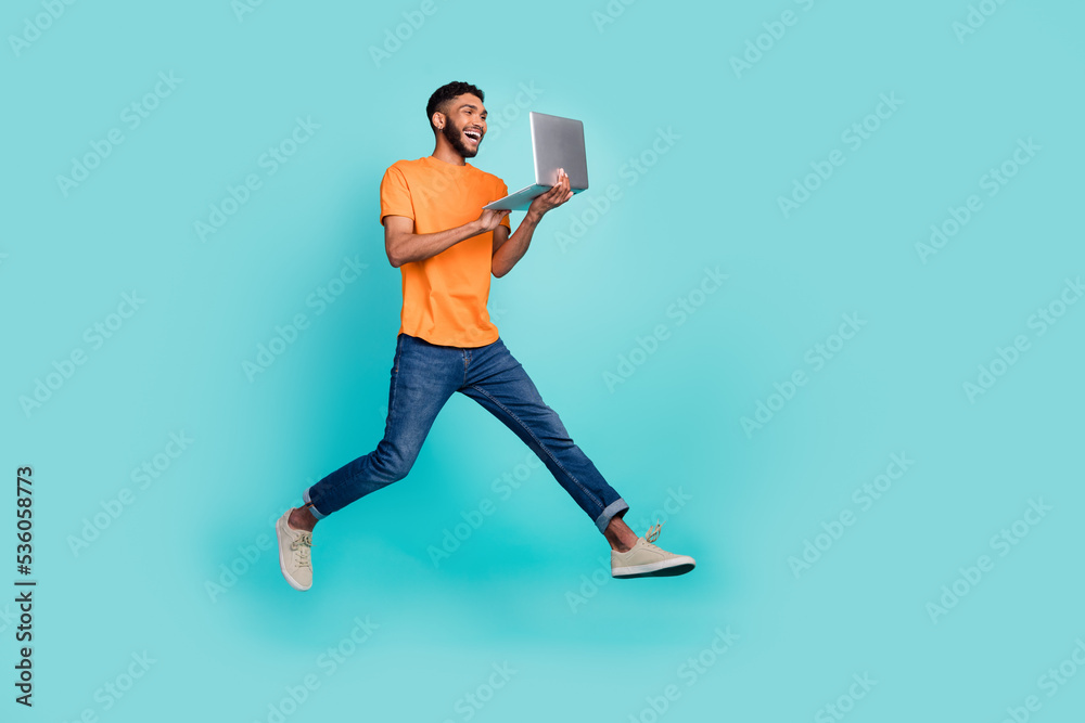 Full size portrait of excited crazy person jumping use netbook isolated on teal color background