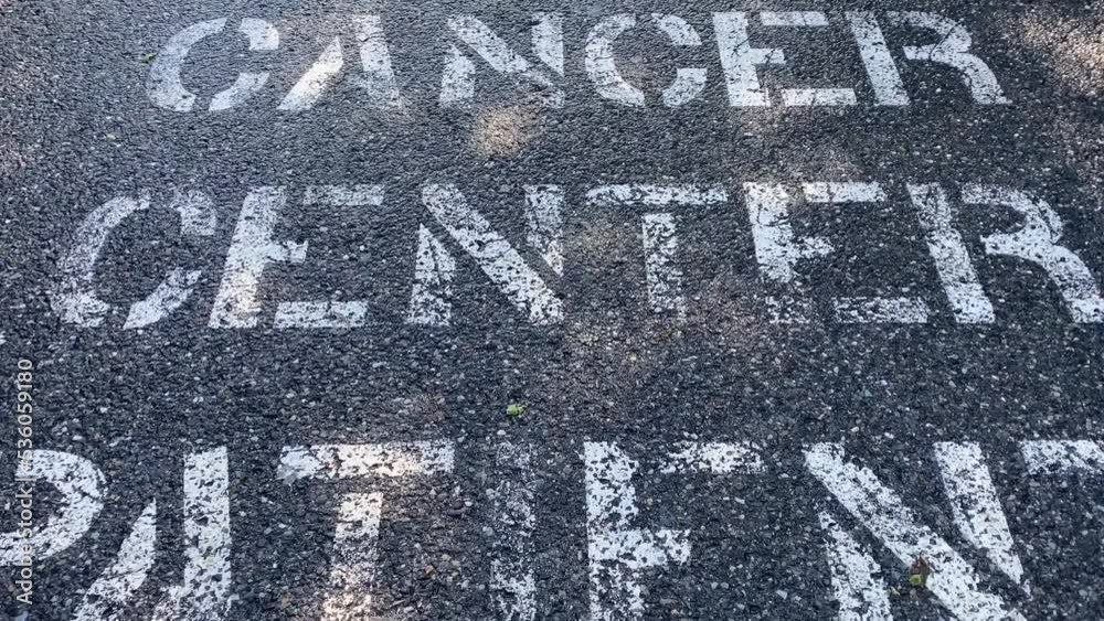tarmac hospital parking lot with white text painted on the lot stating Cancer center patient parking tarmac hospital parking lot with white text painted on the lot stating Cancer center patient parking