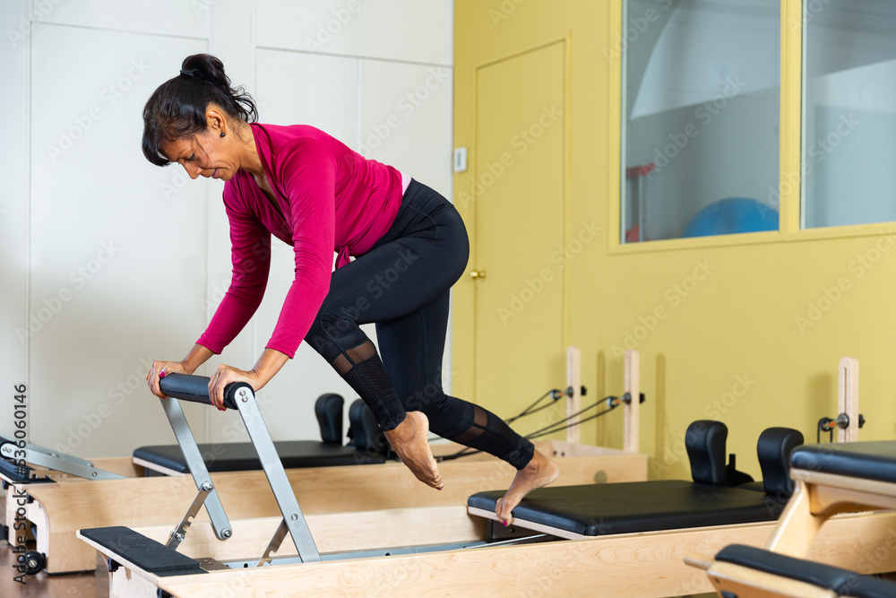 In fitness room. Woman during training on simulator