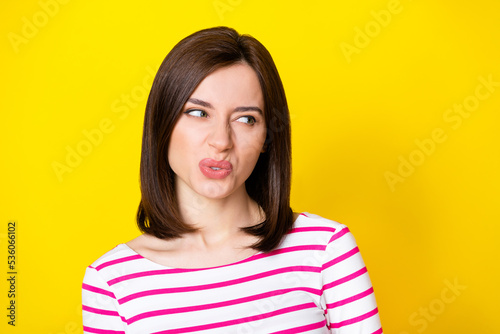 Closeup photo of young attractive nice woman looking empty space suspicious isolated on yellow color background photo