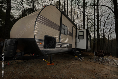 Travel trailer after dusk at a campsite © Guy Sagi