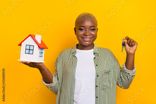 Photo of attractive positive person arms hold little house key isolated on yellow color background
