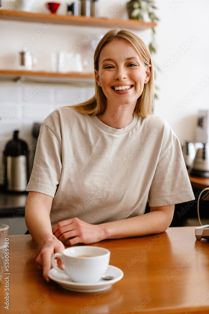 Young beautiful attractive long-haired smiling woman with cup of tea Young beautiful attractive long-haired smiling woman with cup of tea