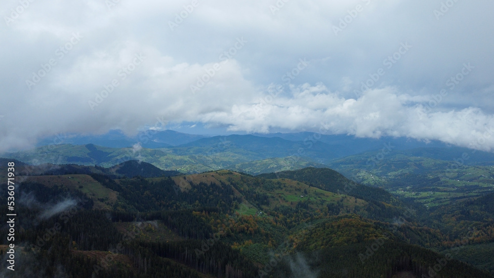 Panorama of forest covered by low clouds. Autumn rain and fog on the mountain hills. Misty fall woodland. Panorama of forest covered by low clouds. Autumn rain and fog on the mountain hills. Misty fall woodland.