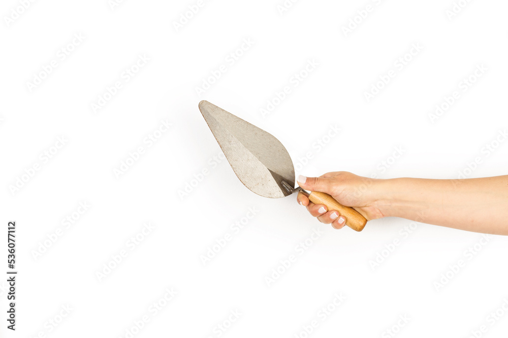 Mano de mujer sosteniendo una paleta de albañil sobre un fondo blanco liso y aislado. Vista de frente y de cerca. Copy space Mano de mujer sosteniendo una paleta de albañil sobre un fondo blanco liso y aislado. Vista de frente y de cerca. Copy space