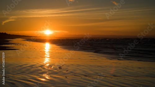  A warm sunset over a wet reflective surface of the baltic beach