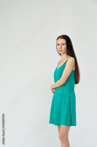 Gorgeous elegant sensual brunette young woman wearing fashion green dress on a white background