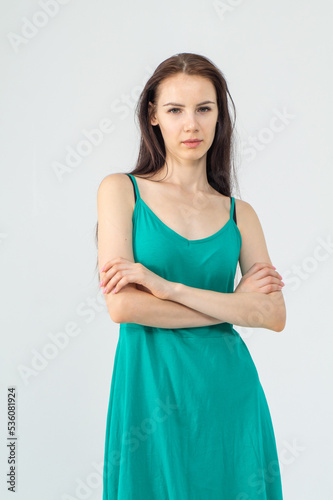 Gorgeous elegant sensual brunette young woman wearing fashion green dress on a white background