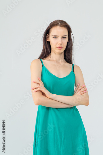 Gorgeous elegant sensual brunette young woman wearing fashion green dress on a white background