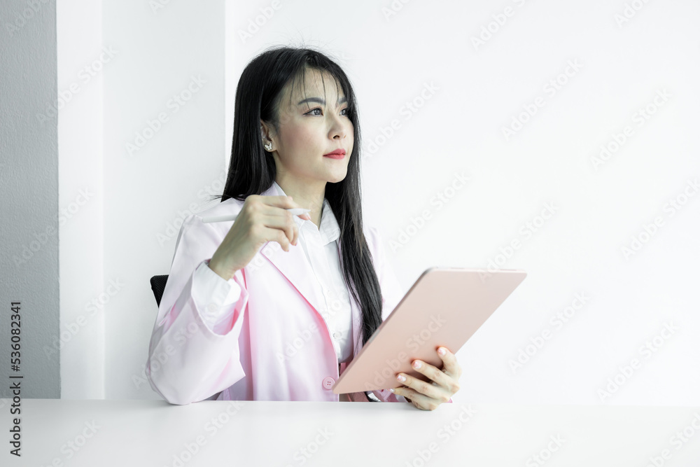Asian woman doctor using digital tablet gadget technology on white background, Asian woman doctor in pink coat with digital tablet, Medical and healthcare working diagnosing examination health. Asian woman doctor using digital tablet gadget technology on white background, Asian woman doctor in pink coat with digital tablet, Medical and healthcare working diagnosing examination health.