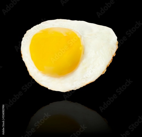 Fried egg levitation isolated on black background.