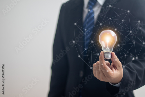 businessman holding a bright light bulb