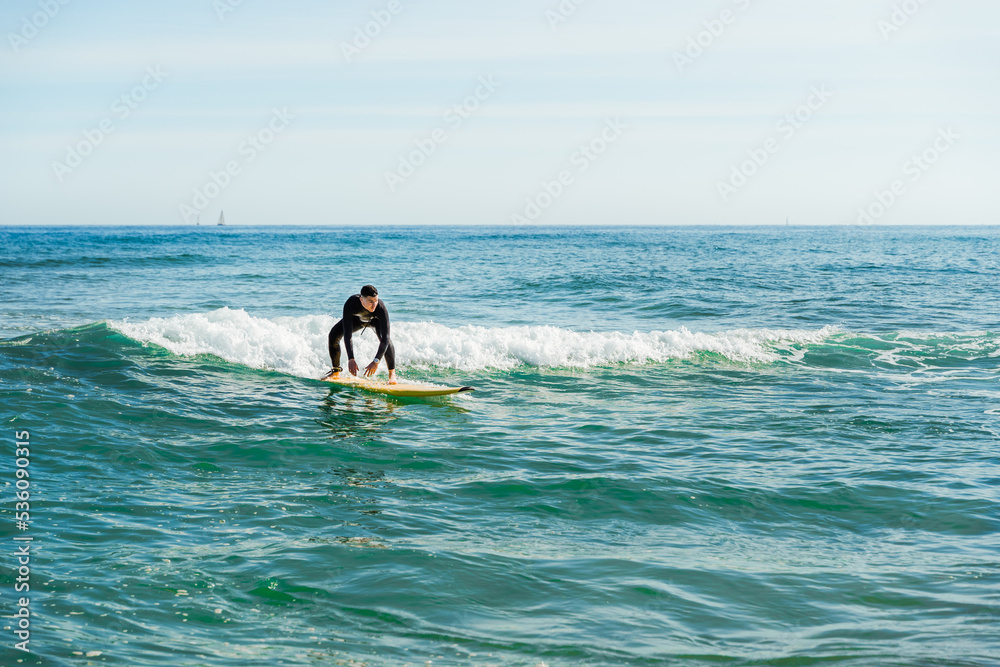 Man on surfboard balancing in wavy ocean Man on surfboard balancing in wavy ocean