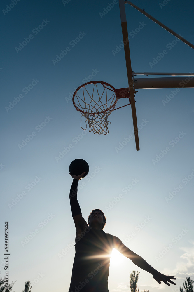Black basketball player kicking ball into net Stock Photo Adobe Stock