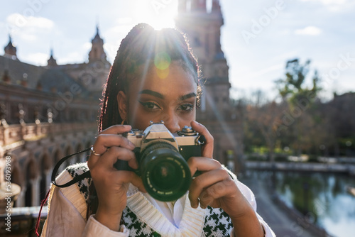 Black woman with photo camera in city
