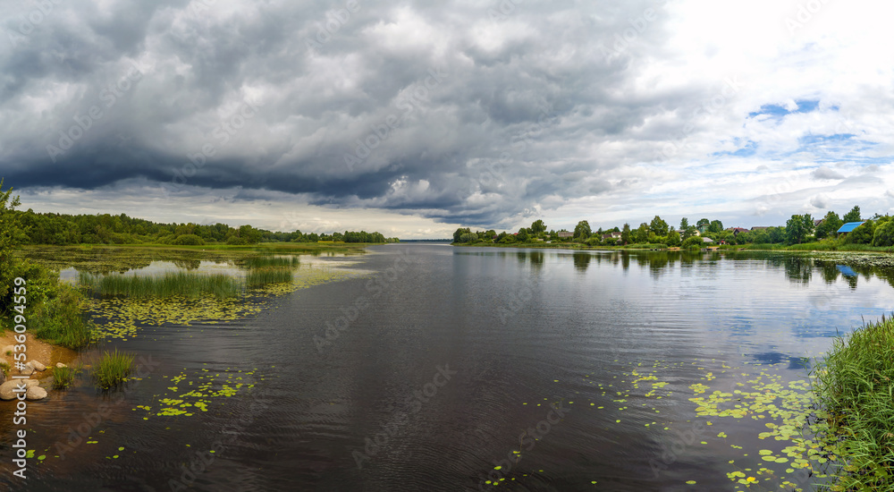 Rain clouds hang over the reservoir. Lake Vrevo . Alexandrovka. Leningrad region.