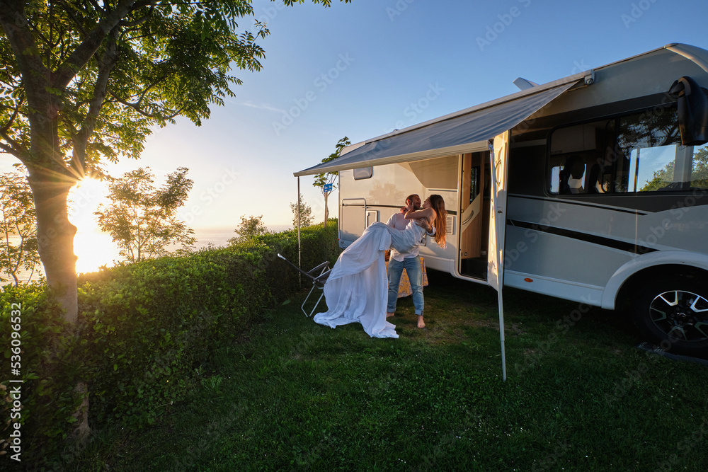 Newlywed couple hugging near camper in nature Stock Photo | Adobe Stock
