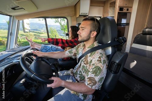 Content traveling couple riding camper during road trip photo