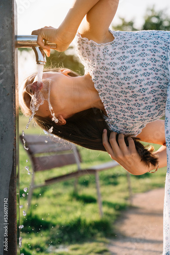 Girl drinking water from standpipe